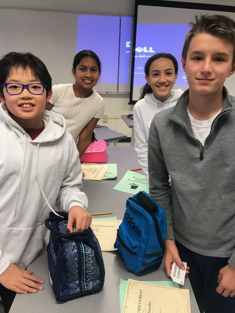 Four students standing at a table