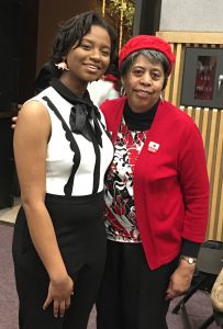 Student standing with her teacher