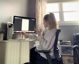 student tutor using her hands while she explains a lesson on her computer