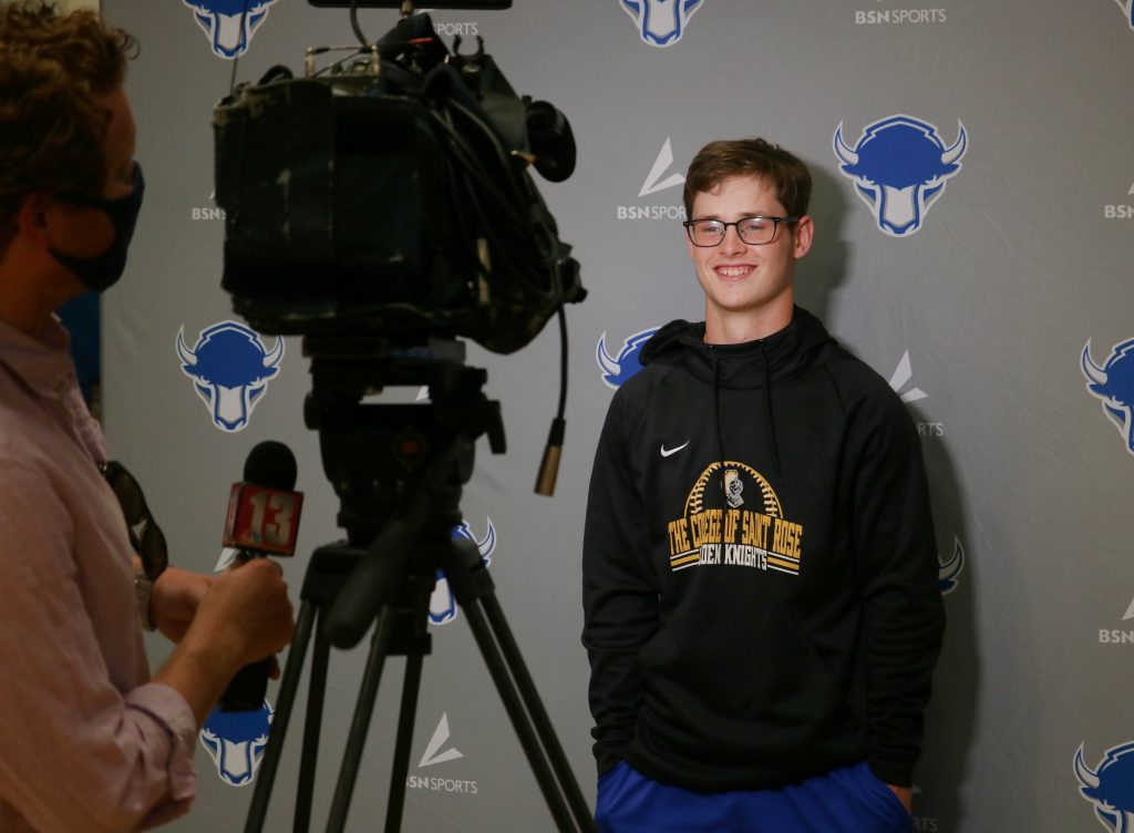 student smiling while talking to the reporter