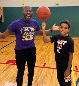 Tay "Firefly" Fisher of the World Famous Harlem Globetrotters with a student