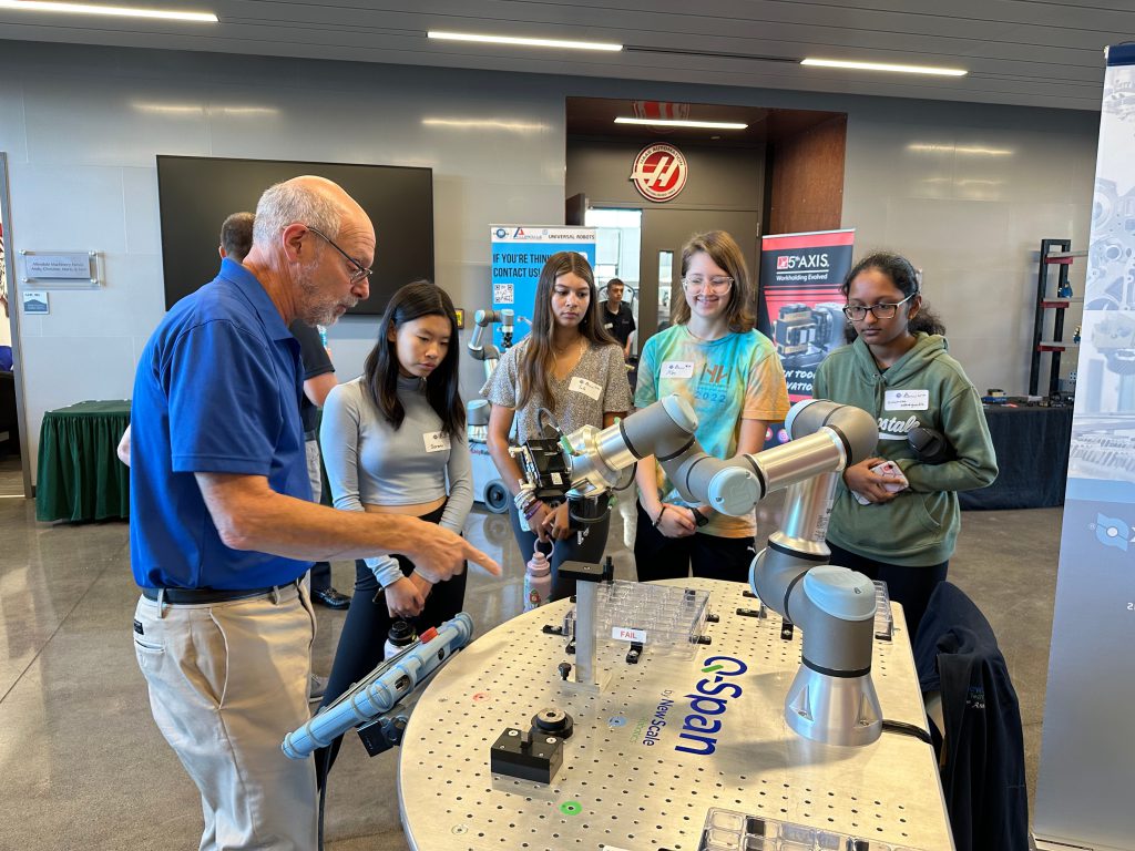 Four students look on as a professional demonstrates some of the technology.