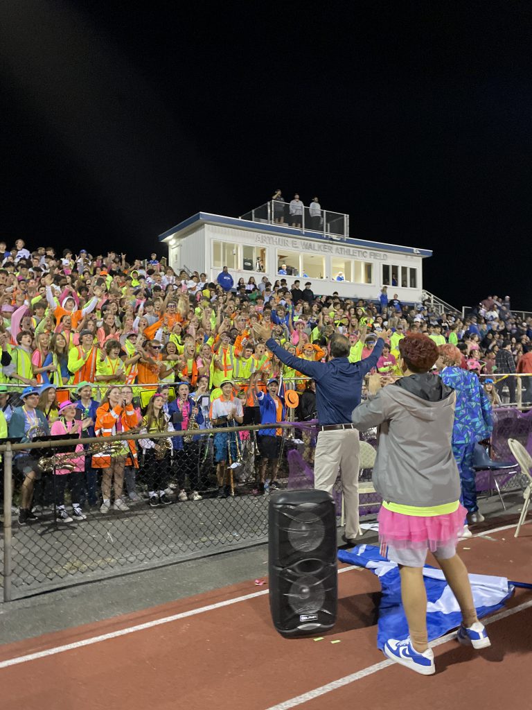 The student section known as The Barn wearing neon for the Colonie Cup game.