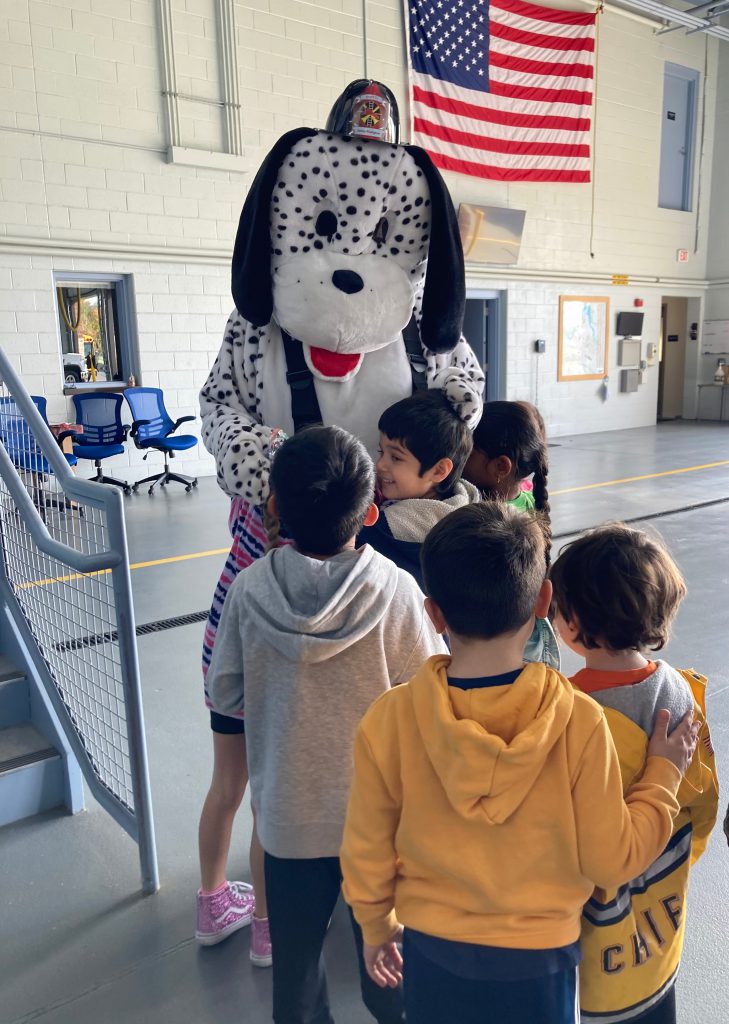 An image of students hugging the fire dog mascot.