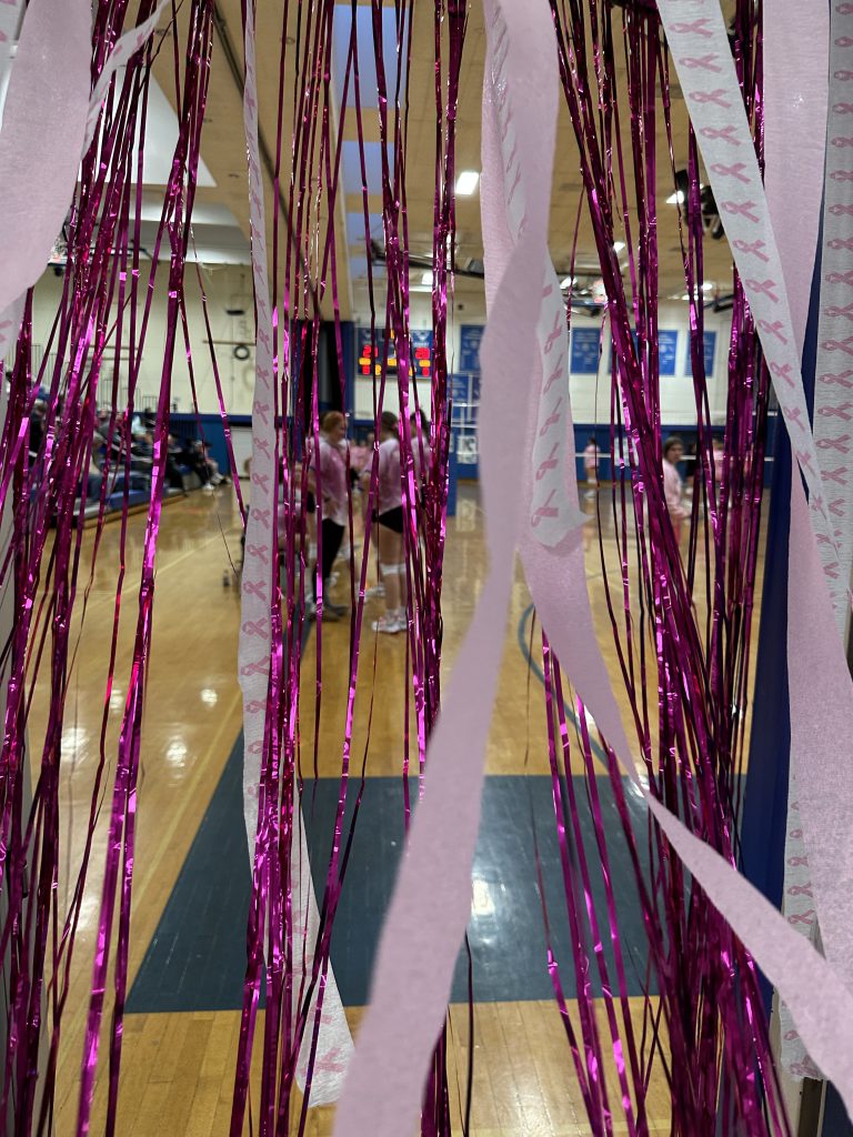 An image of pink streamers and decorations over the doorway to the gym.