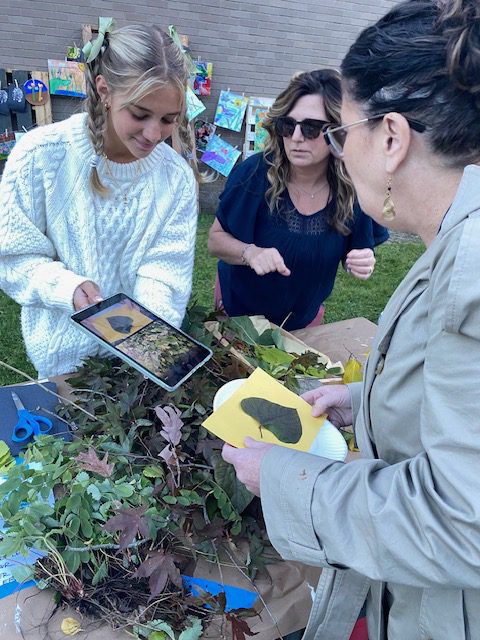 An image of Superintendent Kathleen Skeals learning about leaves from a student.