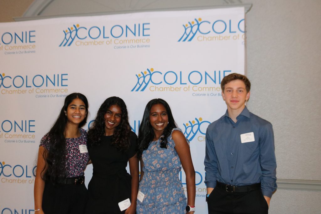 An image of four Shaker students posing in front of a backdrop at the Emerging Leaders Summit.