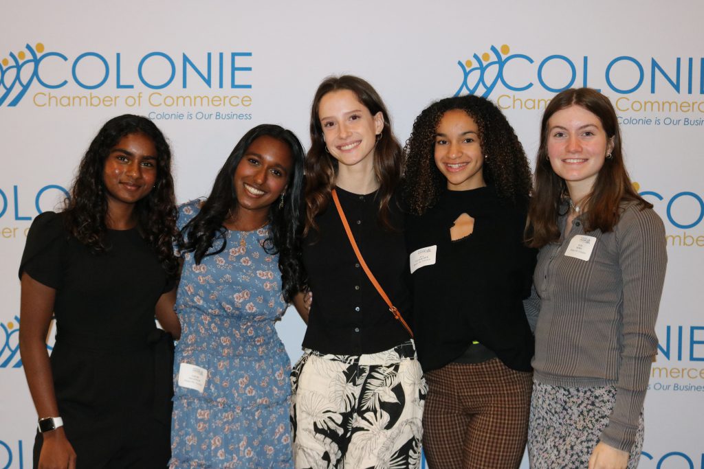 An image of five other Shaker students posing in front of a backdrop at the Emerging Leaders Summit.
