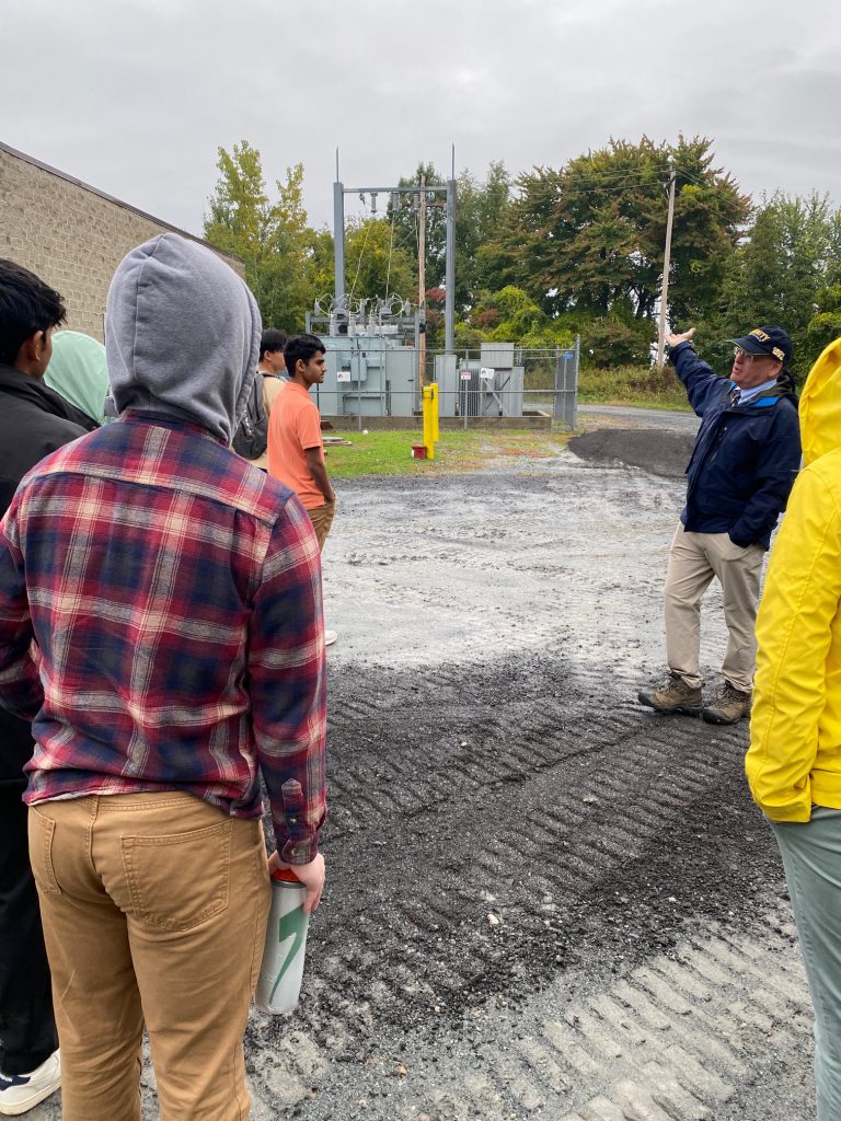 An image of a professional explaining something to the group of students.