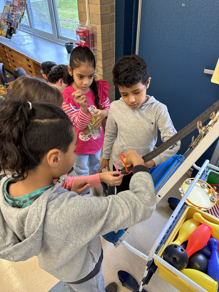 An image of students adjusting the track to their handmade rollercoaster.