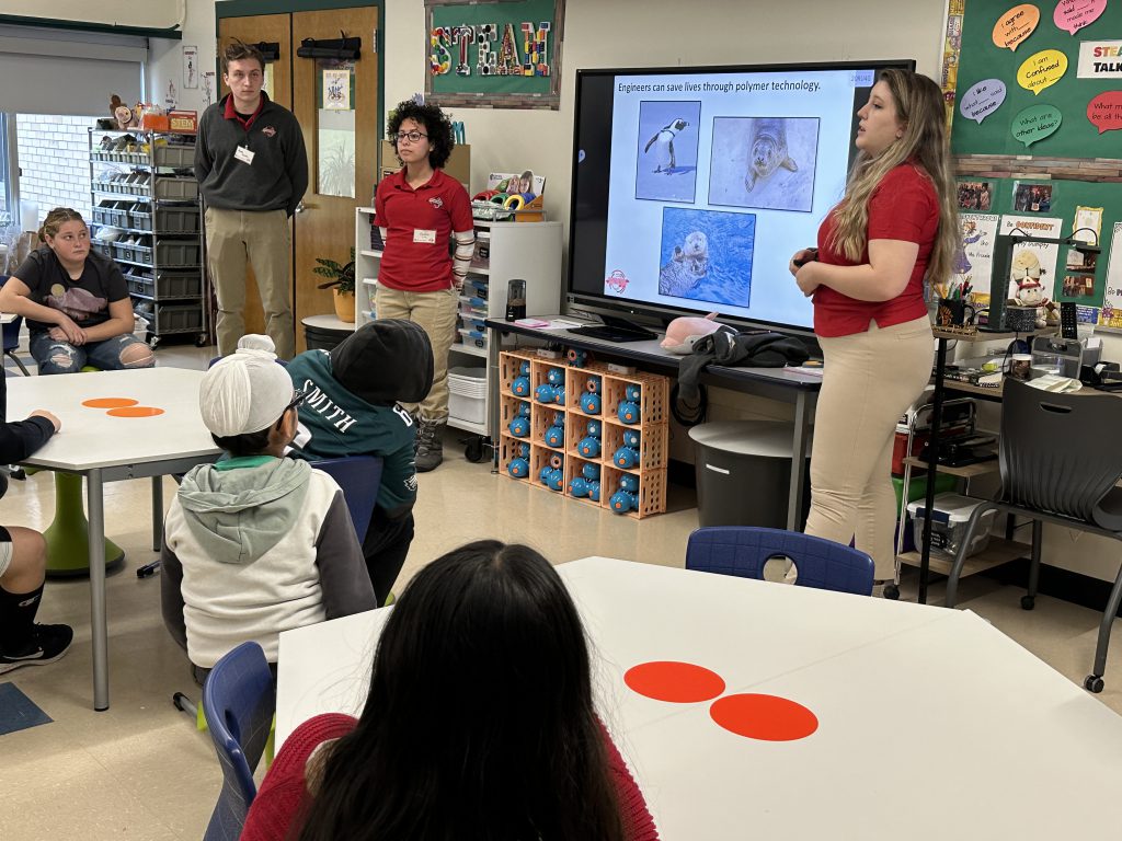 An image of RPI engineering students teaching a lesson in front of a fifth grade class.