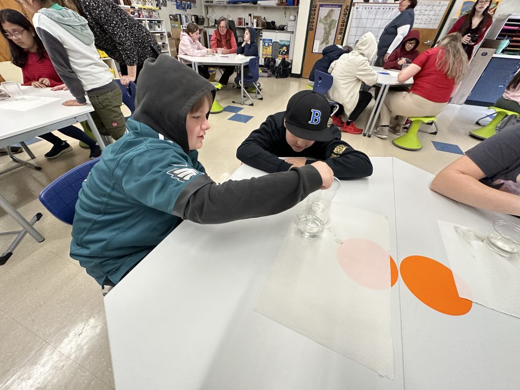 An image of two students working on the oil spill activity.