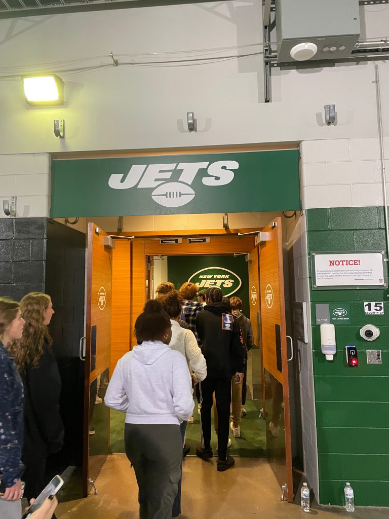 An image of students entering the Jets locker room.