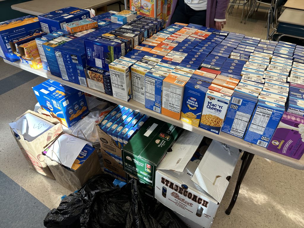 An image of dozens of boxes of macaroni and cheese on a table in the food pantry.