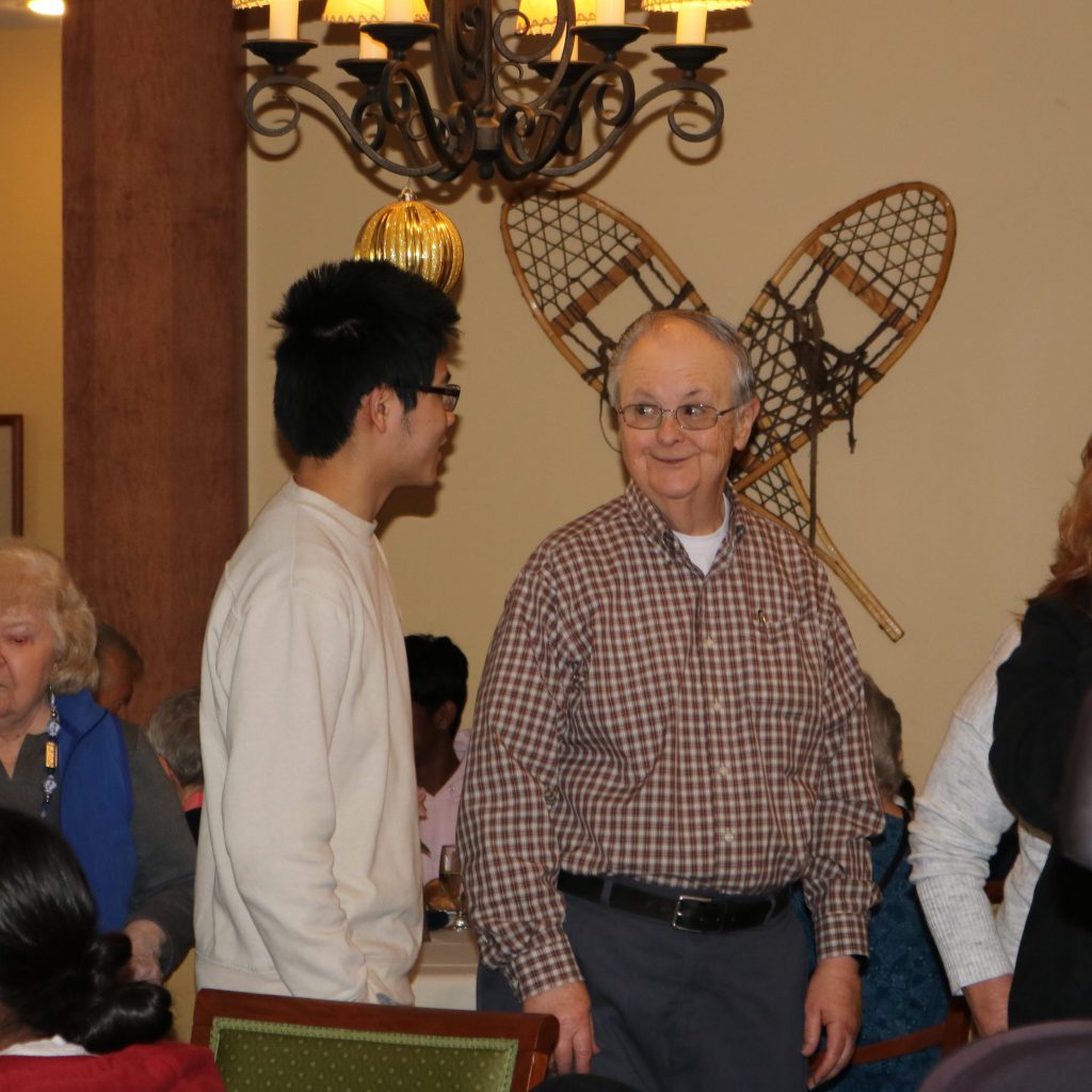 An image of people talking at a lunch buffet line