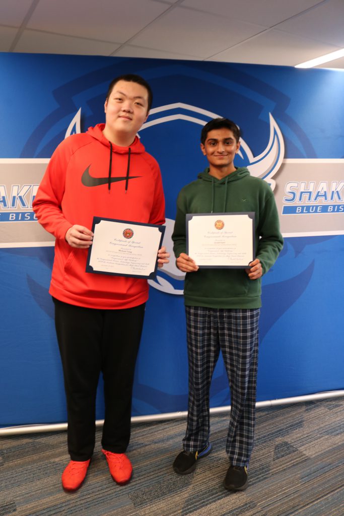 An image of two students from the winning team in the NY-20 Congressional App Challenge holding certificates.