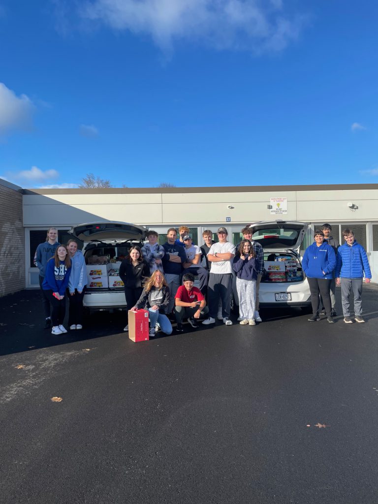 An image of a group of Shaker students from Russian club with the food items they gathered for donation to the Regional Food Bank.