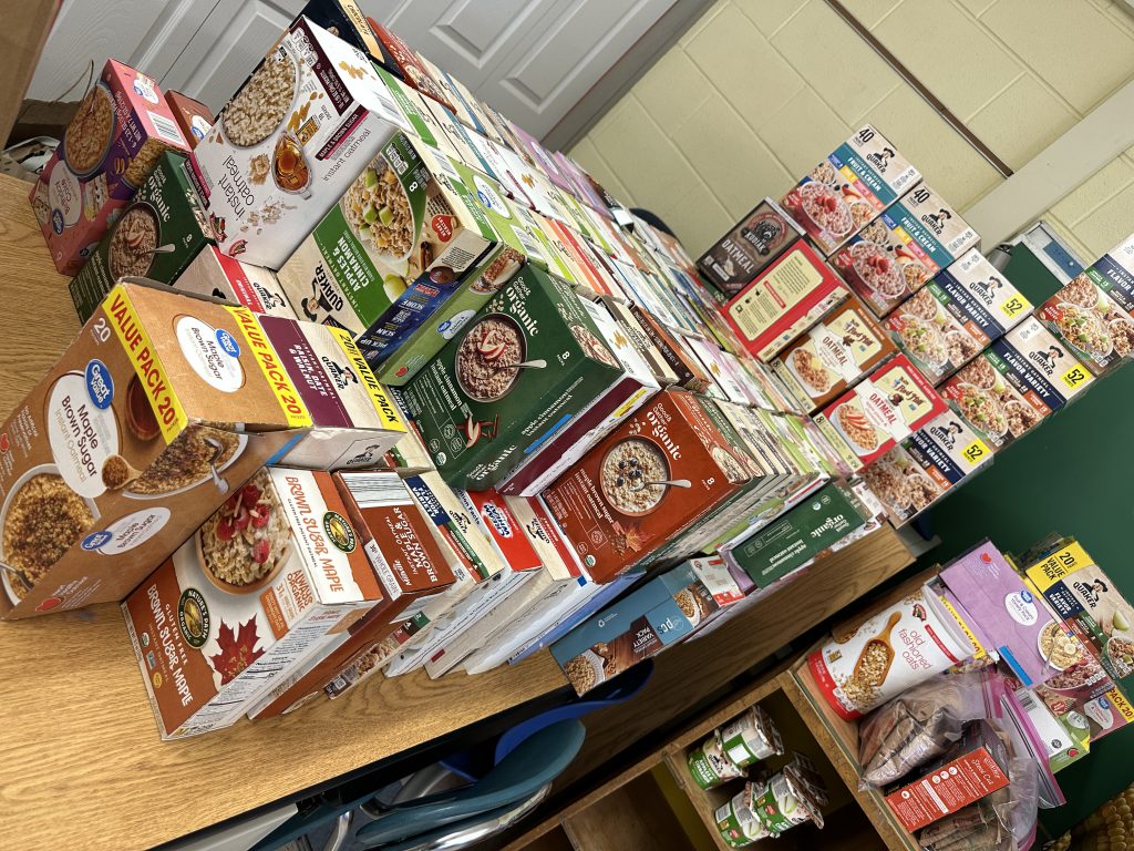 An image of breakfast items like oatmeal and cereal on a shelf in the food pantry.