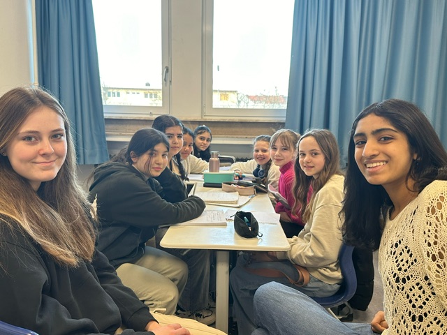 An image of students sitting around a table together.