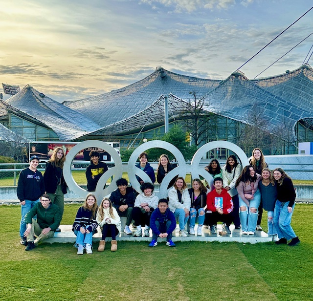 An image of students posing in the Olympic rings at the Olympic Park in Munich.